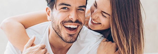 Mann und Frau lächeln sich an, als Zeichen für eine glückliche Beziehung