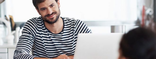 Beruf und Beziehung - Mann vor Laptop versucht beides im Gleichgewicht zu halten