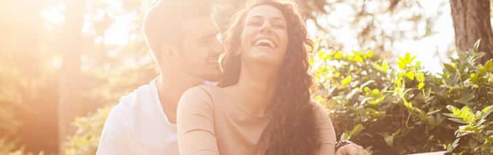 Flirttipps: Frau lachend in den Armen eines Mannes