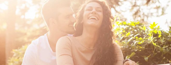 Flirttipps: Frau lachend in den Armen eines Mannes