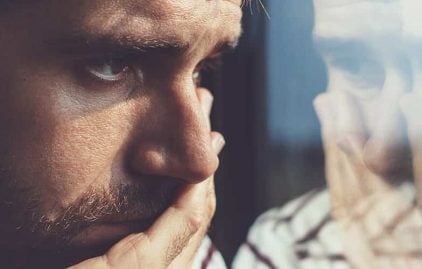 Trennung verarbeiten: Mann schaut nachdenklich aus dem Fenster