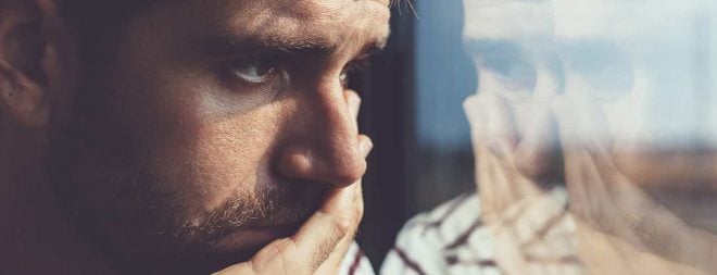 Trennung verarbeiten: Mann schaut nachdenklich aus dem Fenster