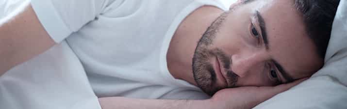 Trennungsangst: Mann liegt im Bett und denkt nach