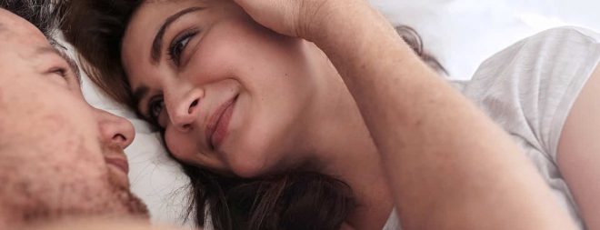 Sex beim ersten Date: Mann und Frau liegen im Bett und schauen sich an