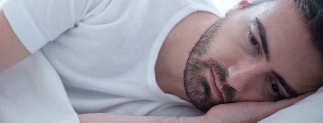 Trennungsangst: Mann liegt im Bett und denkt nach