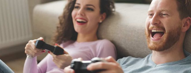 Freundschaft mit dem Ex: Mann und Frau haben Spaß beim Playstation spielen.