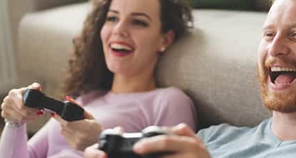 Freundschaft mit dem Ex: Mann und Frau haben Spaß beim Playstation spielen.