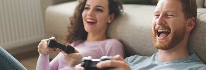Freundschaft mit dem Ex: Mann und Frau haben Spaß beim Playstation spielen.