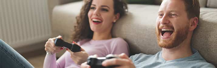 Freundschaft mit dem Ex: Mann und Frau haben Spaß beim Playstation spielen.
