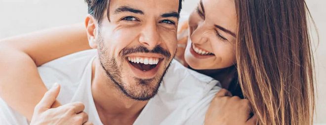 Mann und Frau lächeln sich an, als Zeichen für eine glückliche Beziehung