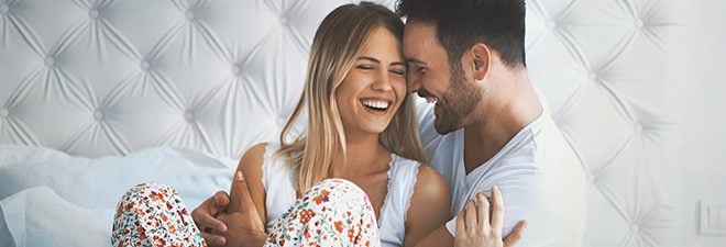 Rosarote Brille: Mann und Frau sind verliebt und frühstücken im Bett