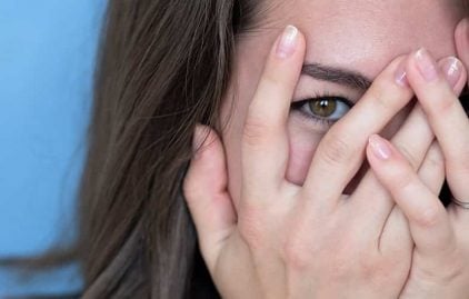 Frau hat Angst vor dem ersten Date - hält sich die Hände vors Gesicht