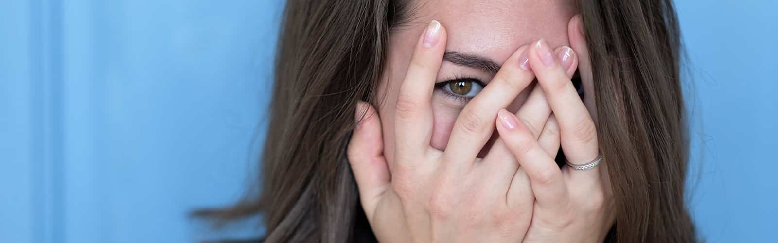 Frau hat Angst vor dem ersten Date - hält sich die Hände vors Gesicht