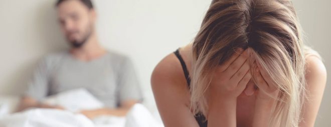 Eine Frau weint auf dem Bett