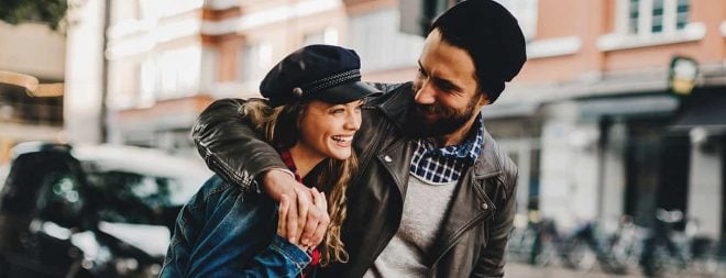Mann lächelt und umarmt Frau - er kann Frauen zum lachen bringen