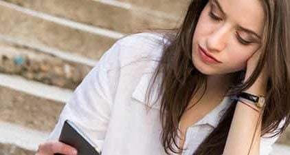 Eifersüchtig auf Ex: Frau schaut nachdenklich auf das Handy