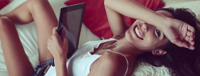 Wie schreibe ich Männer an? Fragt sich Frau schmunselnt auf der Couch mit Tablet in der Hand