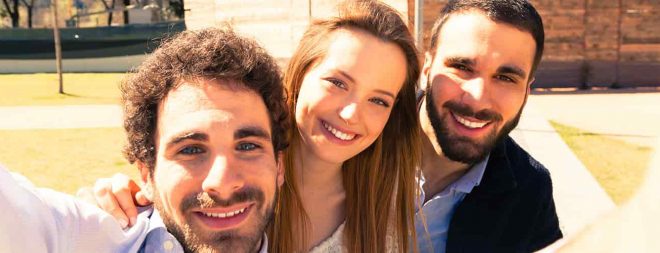 Frau macht Mann eifersüchtig, indem Sieein Selfie mit zwei anderen Männern macht