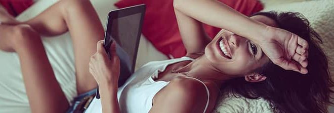 Wie schreibe ich Männer an? Fragt sich Frau schmunselnt auf der Couch mit Tablet in der Hand