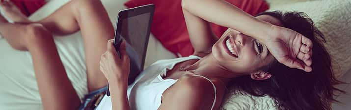 Wie schreibe ich Männer an? Fragt sich Frau schmunselnt auf der Couch mit Tablet in der Hand
