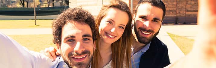 Frau macht Mann eifersüchtig, indem Sieein Selfie mit zwei anderen Männern macht