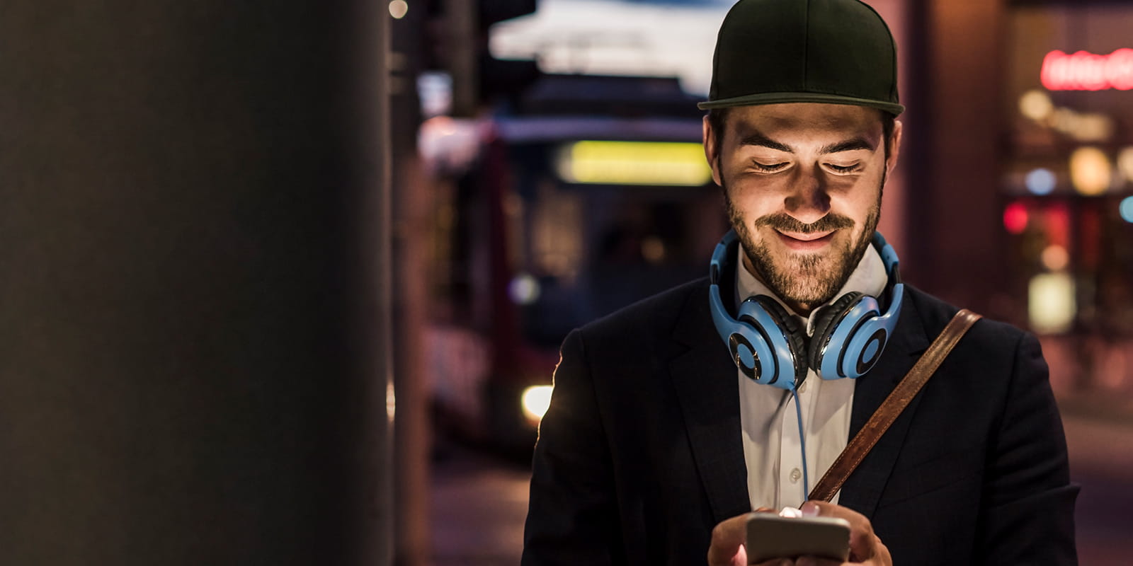 Mann mit Cap liest auf dem Handy