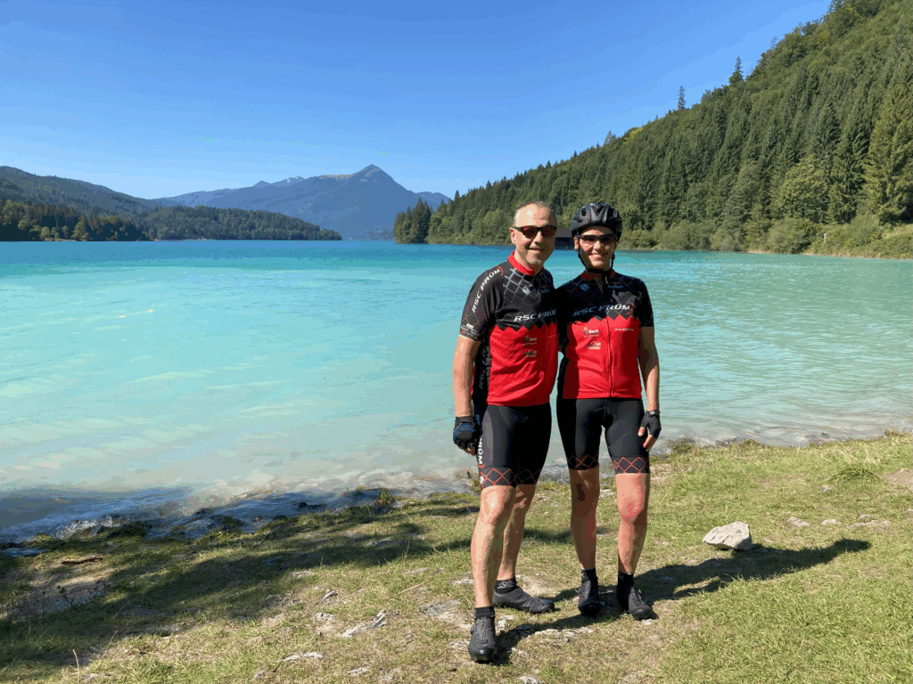 Ein Paar steht in Sportkleidung vor einem Bergsee.