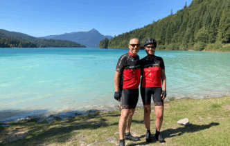 Ein Paar steht in Sportkleidung vor einem Bergsee.