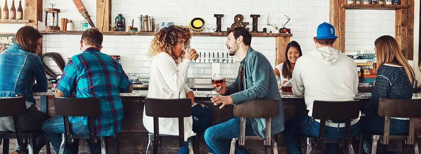 Ein Mann und eine Frau reden in einem belebten Café.